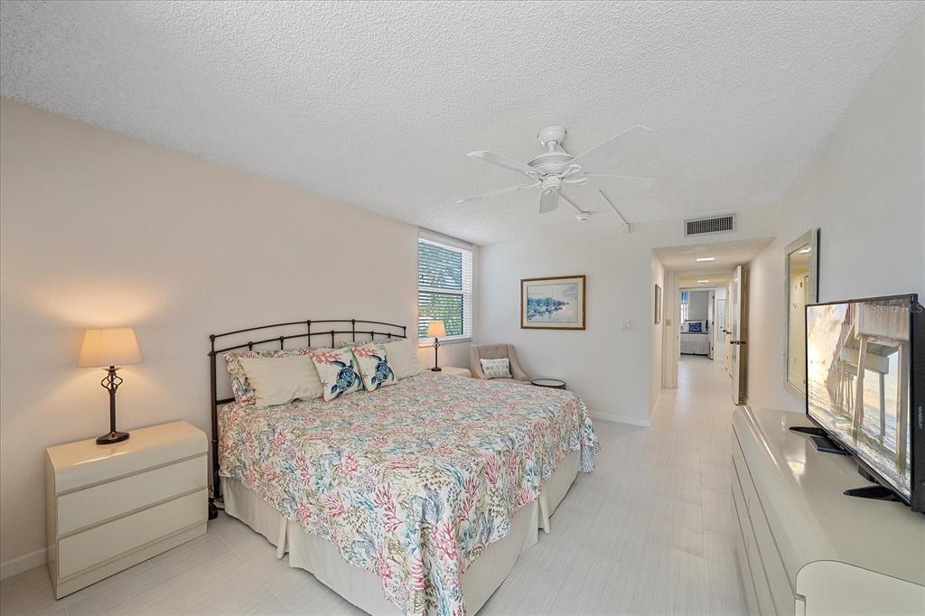 618 Bayport Way, Unit 618 Longboat Key, FL 34228 - Photo 18 of 47 a bedroom with a large bed and a chandelier