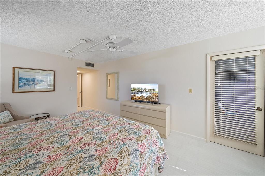 618 Bayport Way, Unit 618 Longboat Key, FL 34228 - Photo 19 of 47 a bedroom with a bed and a flat screen tv