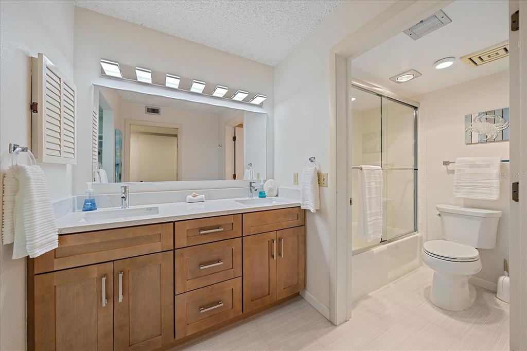 618 Bayport Way, Unit 618 Longboat Key, FL 34228 - Photo 21 of 47 a spacious bathroom with a double vanity sink toilet and a mirror