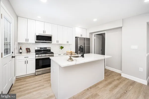 a kitchen with kitchen island a sink stove and refrigerator