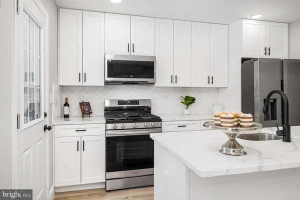 a kitchen with stainless steel appliances white cabinets and white appliances