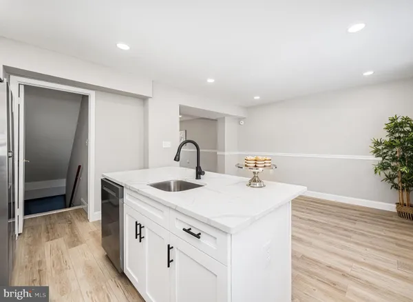 a view of a sink and dishwasher with wooden floor