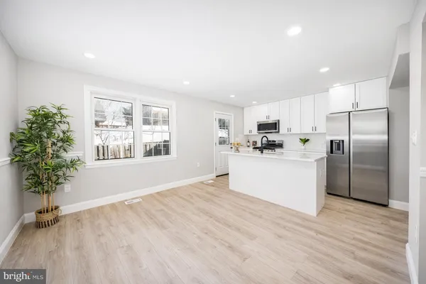 a view of a kitchen with sink and refrigerator