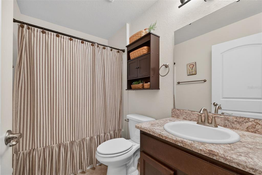 2429 Twin Lake View Road Winter Haven, FL 33881 - Photo 34 of 37 a bathroom with a granite countertop sink toilet and mirror