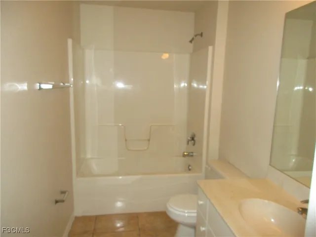 a bathroom with a bathtub shower sink mirror and toilet