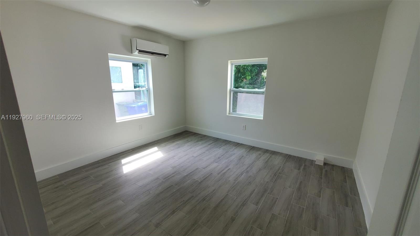 560 Northwest 53rd Street Miami, FL 33127 - Photo 12 of 12 a view of an empty room with wooden floor and a window