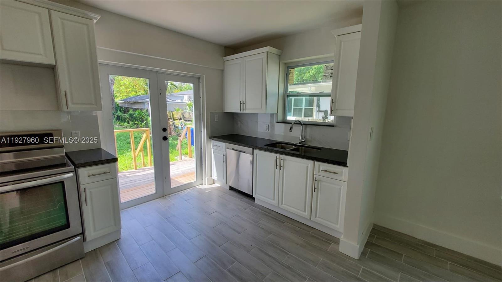560 Northwest 53rd Street Miami, FL 33127 - Photo 3 of 12 a kitchen with a sink a wooden floor and a window