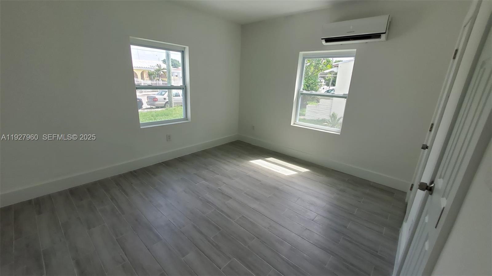 560 Northwest 53rd Street Miami, FL 33127 - Photo 5 of 12 a view of an empty room with wooden floor and a window