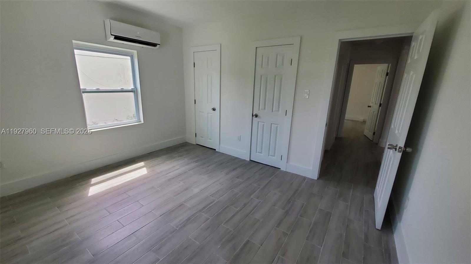 560 Northwest 53rd Street Miami, FL 33127 - Photo 6 of 12 an empty room with wooden floor and windows