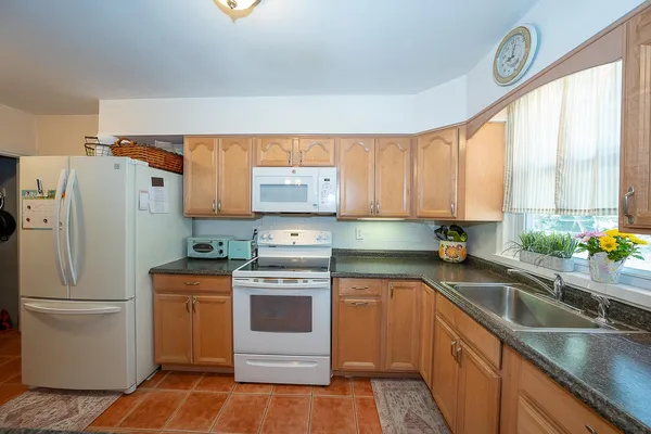 a kitchen with a sink a refrigerator and cabinets