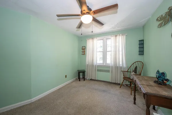a view of a workspace with furniture and a window