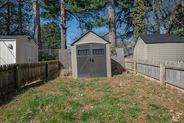 a view of a house with wooden fence and a yard