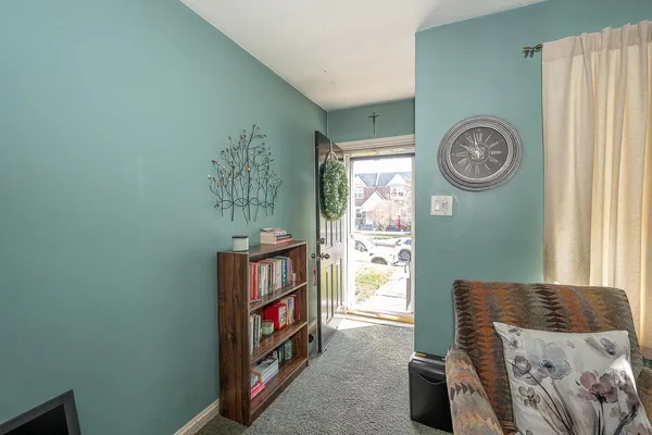 a living room with baby crib and a window