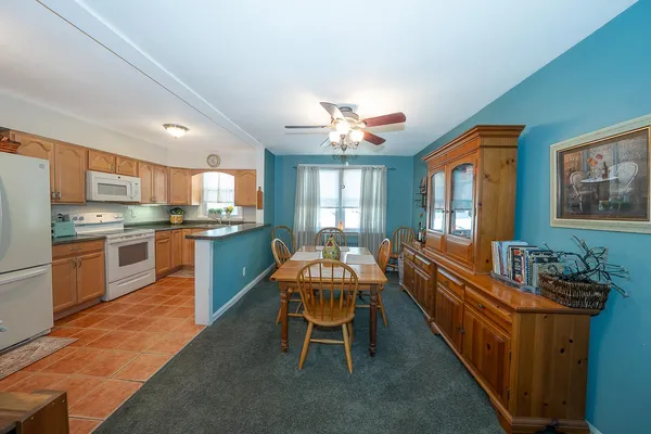 a kitchen with a dining table chairs and refrigerator