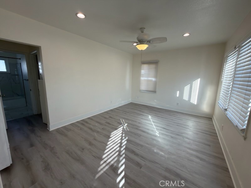 15356 Merrill Avenue, Unit 1 Fontana, CA 92335 - Photo 4 of 8 an empty room with wooden floor and windows