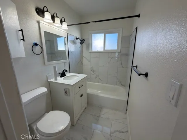 a bathroom with a sink a mirror a toilet and bathtub