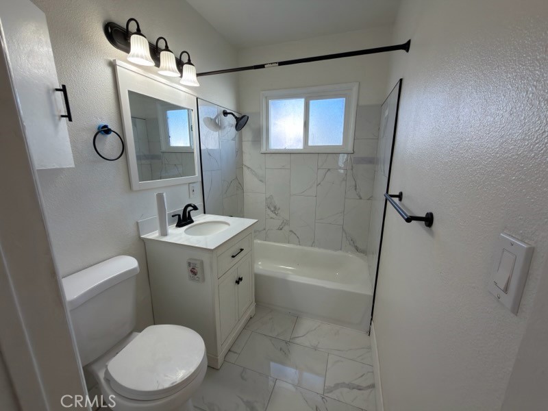 15356 Merrill Avenue, Unit 1 Fontana, CA 92335 - Photo 7 of 8 a bathroom with a sink a mirror a toilet and bathtub