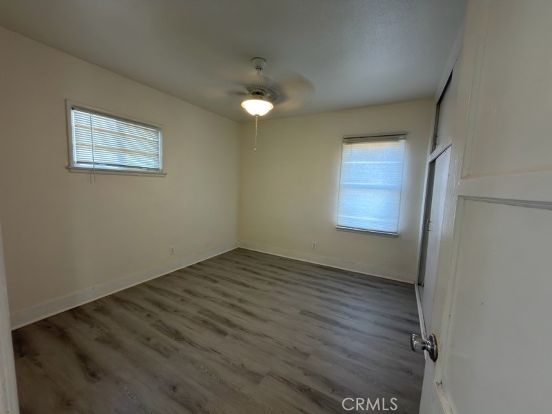 15356 Merrill Avenue, Unit 1 Fontana, CA 92335 - Photo 8 of 8 an empty room with wooden floor and windows