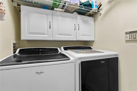 a view of a kitchen with a stove wooden floor and cabinets