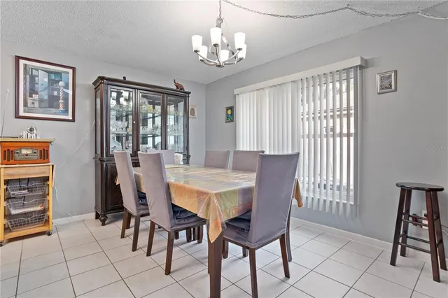 a room with furniture a chandelier a large window and potted plants
