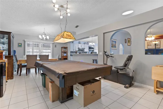 a large kitchen with stainless steel appliances granite countertop a stove a sink dishwasher and a dining table with the living room view