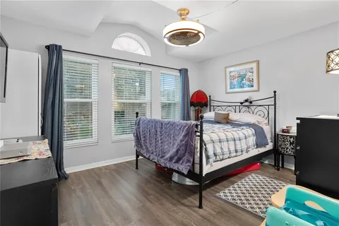 a bedroom with a bed and wooden floor