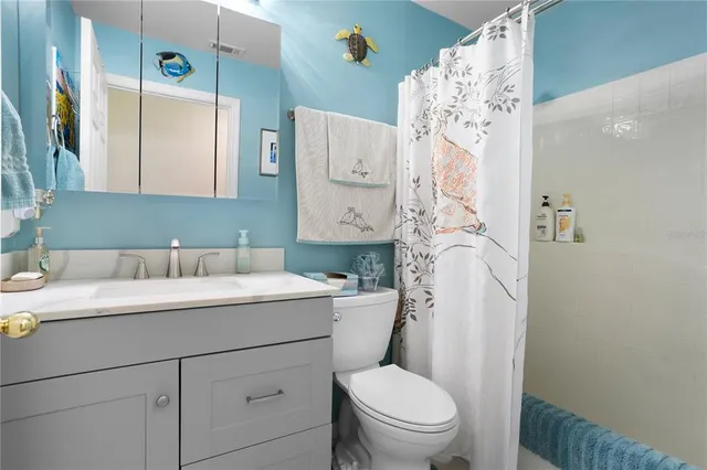a bathroom with a sink vanity mirror and toilet