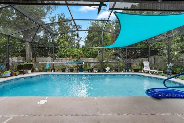 a view of a swimming pool with a yard and sitting area