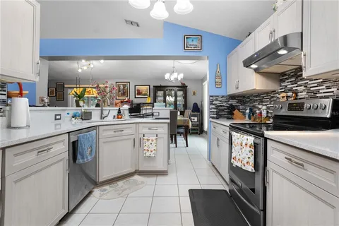 a kitchen with white cabinets and appliances