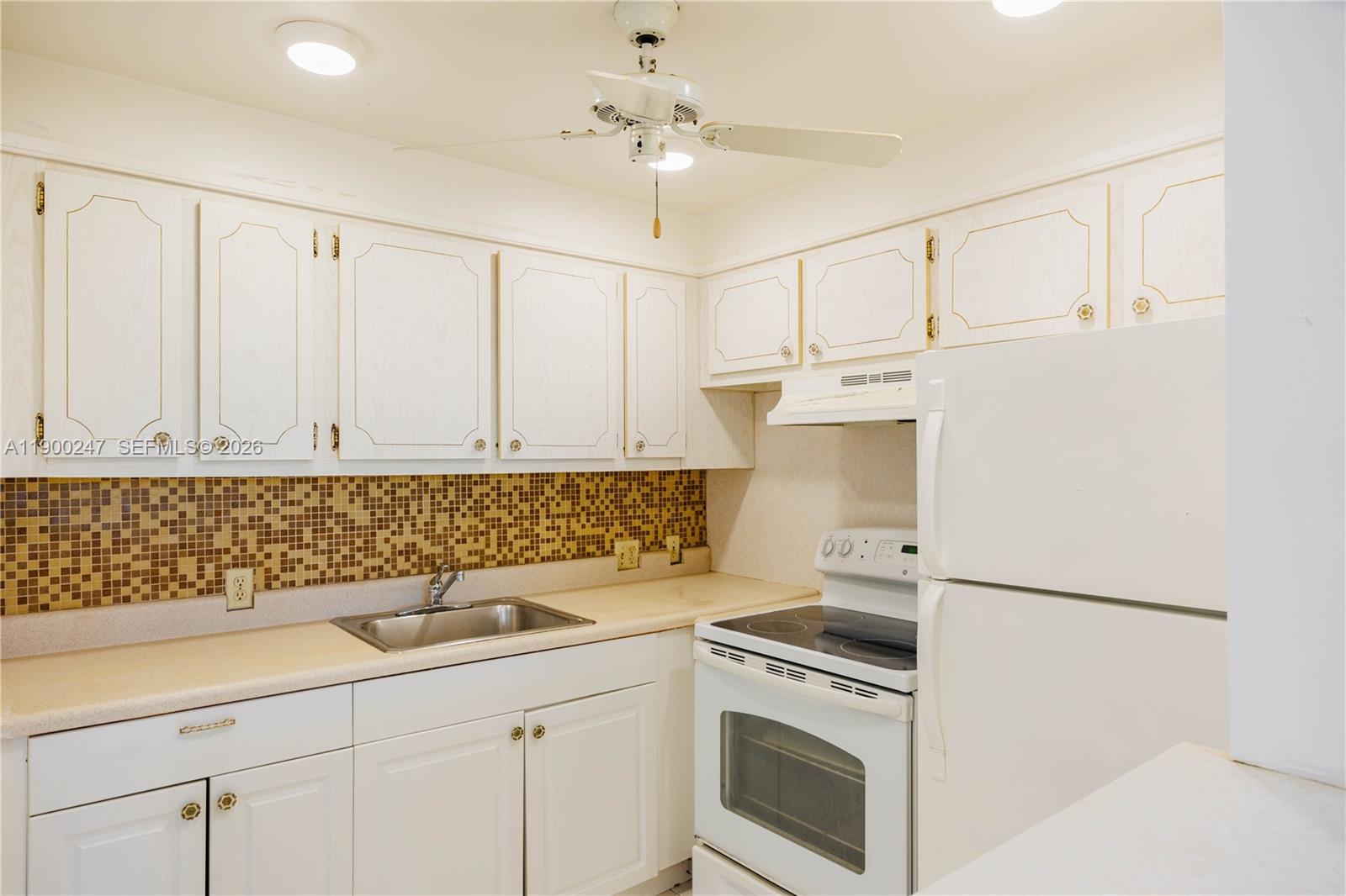 303 Preston H, Unit 303 Boca Raton, FL 33434 - Photo 12 of 50 a kitchen with white cabinets and white appliances