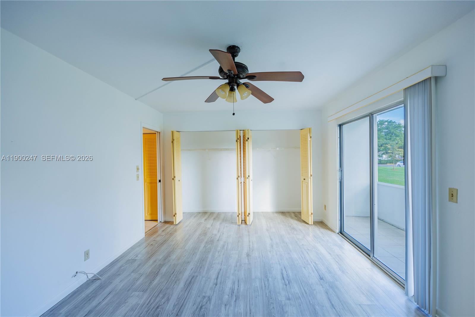 303 Preston H, Unit 303 Boca Raton, FL 33434 - Photo 28 of 50 a view of a room with wooden floor a ceiling fan and windows