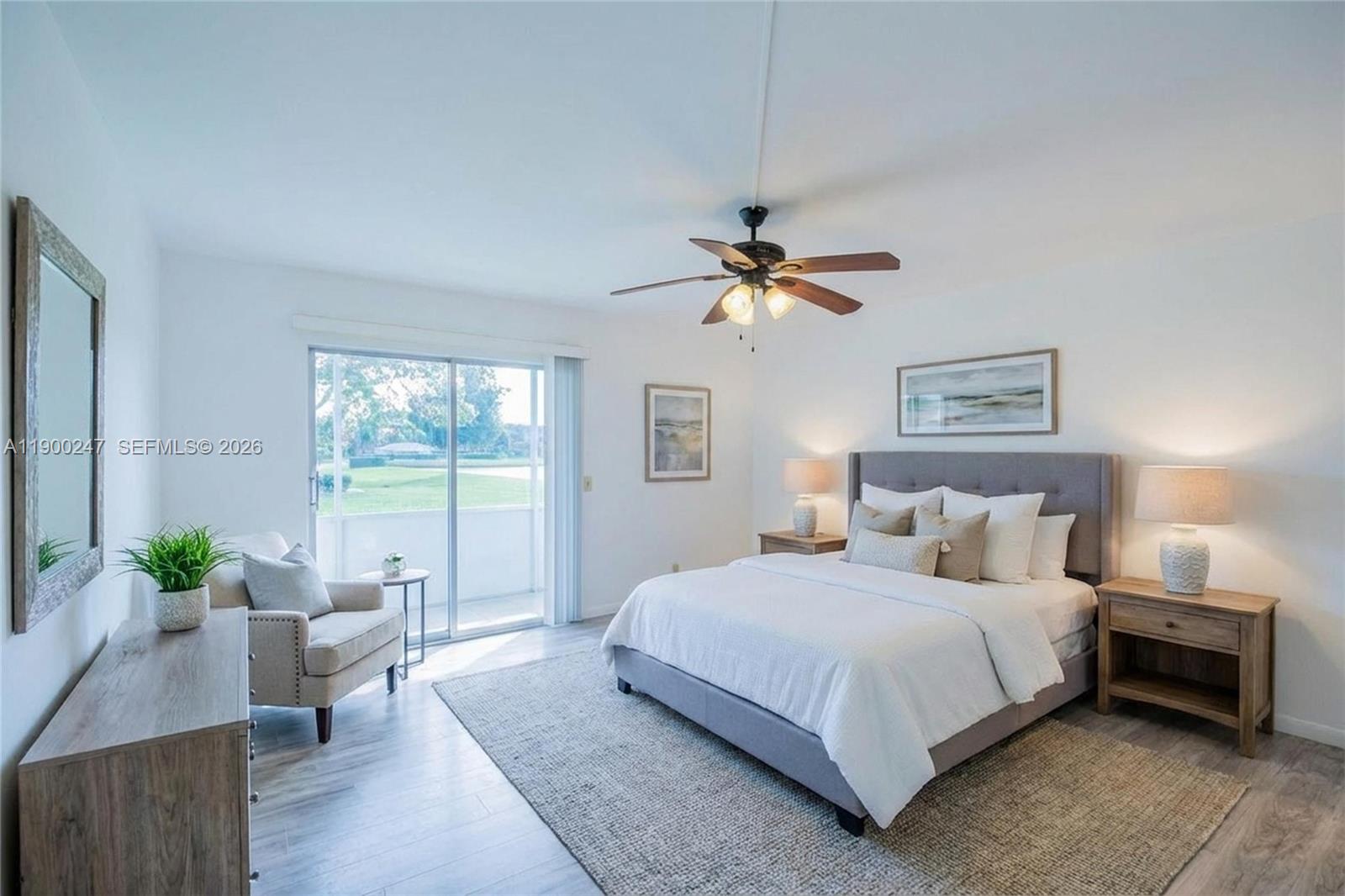 303 Preston H, Unit 303 Boca Raton, FL 33434 - Photo 48 of 50 a bedroom with a large bed and a chandelier