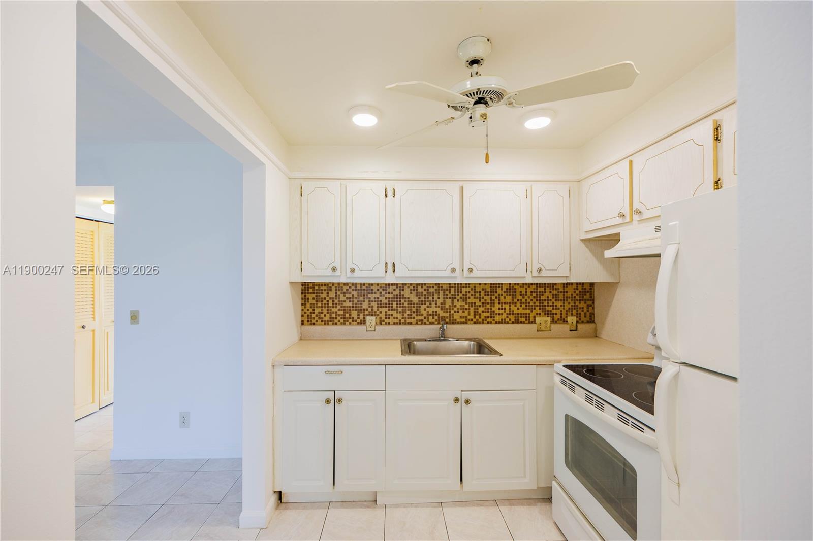 303 Preston H, Unit 303 Boca Raton, FL 33434 - Photo 10 of 50 a kitchen with a sink dishwasher a stove and a refrigerator