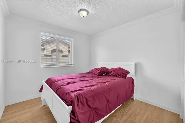 a bed sitting in a bedroom next to a window