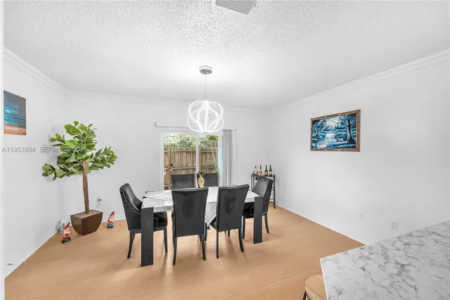 a view of a dining room with furniture and chandelier