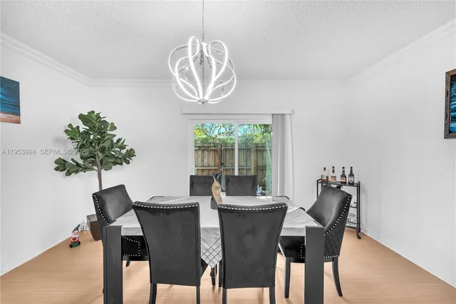 a dining room with furniture a chandelier and wooden floor