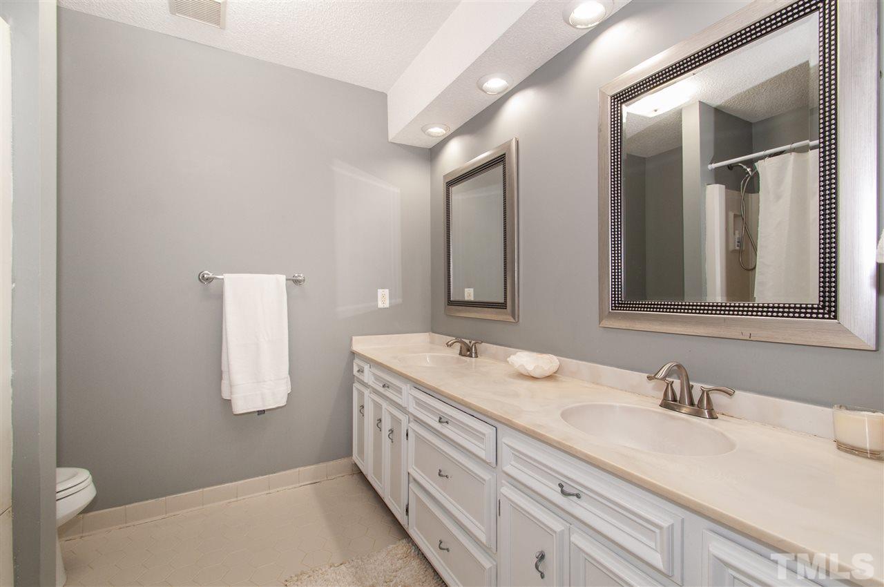 2712 Rue Sans Famille Raleigh, NC 27607 - Photo 14 of 28 a bathroom with a double vanity sink and a mirror