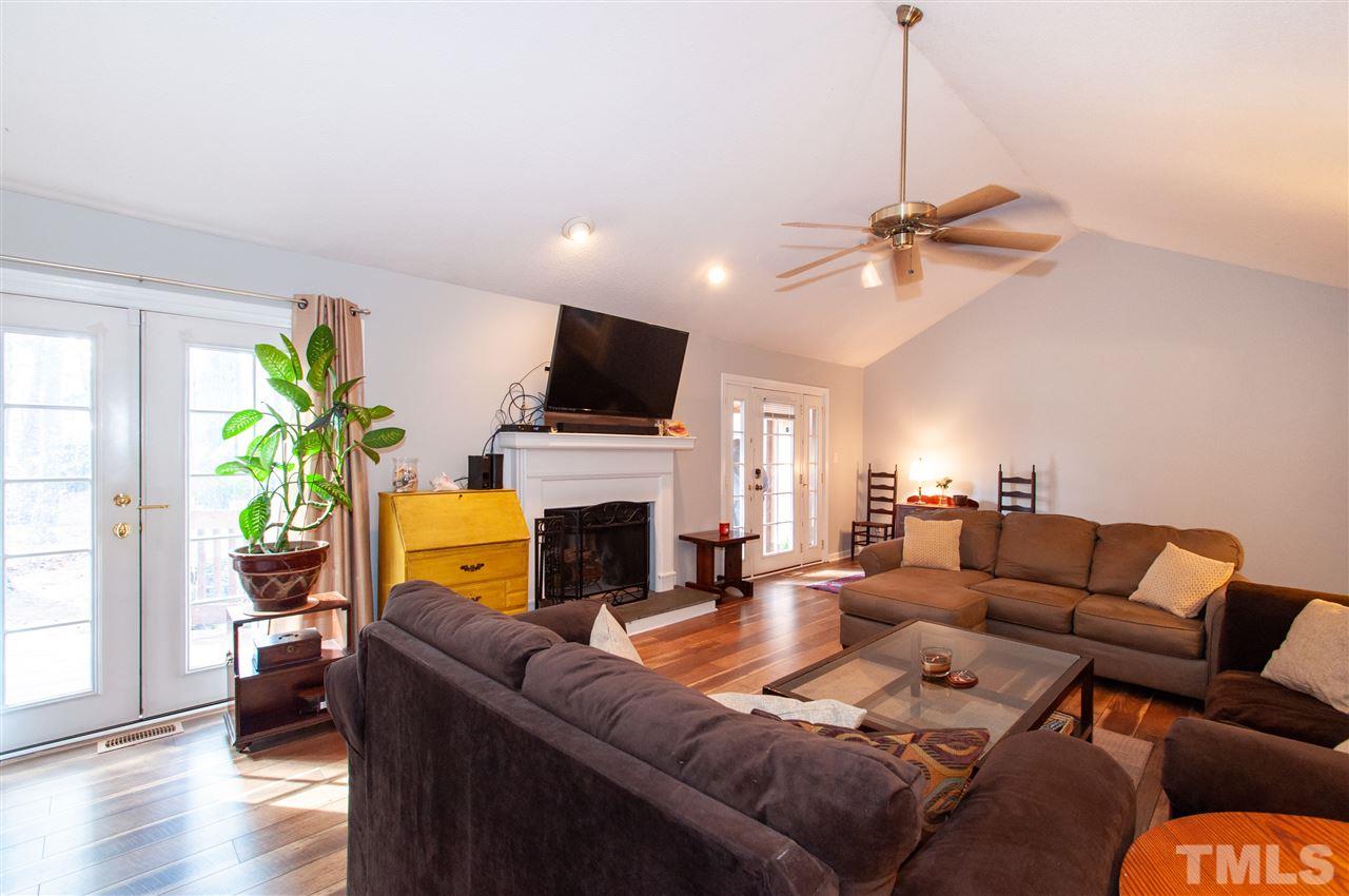 2712 Rue Sans Famille Raleigh, NC 27607 - Photo 4 of 28 a living room with furniture a fireplace and a flat screen tv