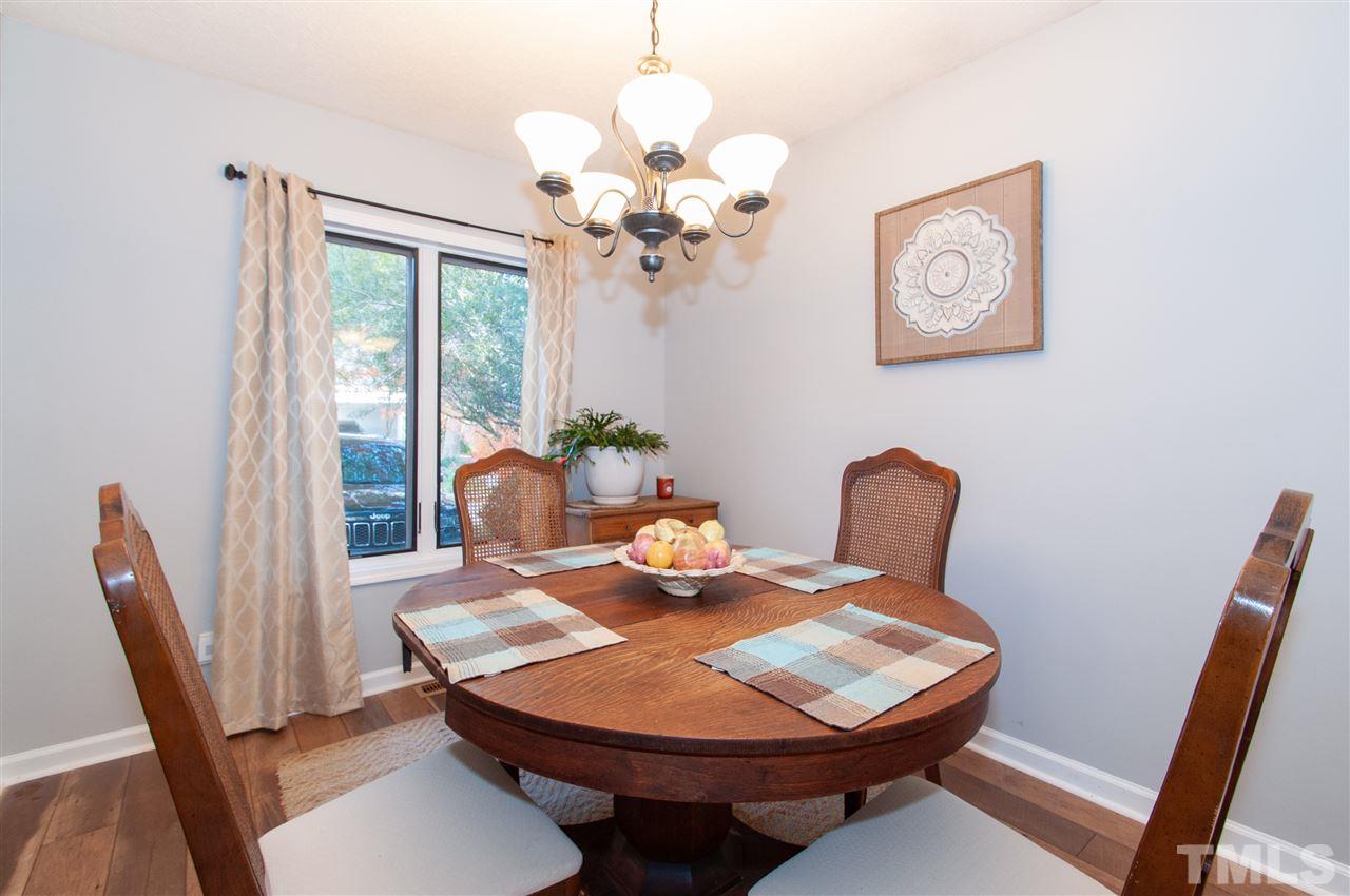 2712 Rue Sans Famille Raleigh, NC 27607 - Photo 7 of 28 a view of a dining room with furniture wooden floor and a chandelier