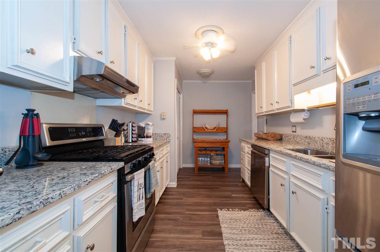 2712 Rue Sans Famille Raleigh, NC 27607 - Photo 9 of 28 a kitchen with stainless steel appliances granite countertop a sink stove and cabinets