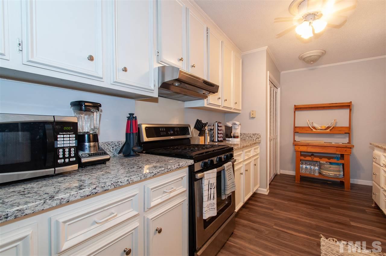 2712 Rue Sans Famille Raleigh, NC 27607 - Photo 10 of 28 a kitchen with stainless steel appliances granite countertop a stove and a sink
