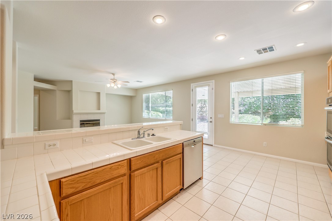 3713 Spring Shadow Road Las Vegas, NV 89129 - Photo 17 of 37 This bright kitchen features ample counter space, dual sinks, and a seamless flow into the adjacent living area with a fireplace.