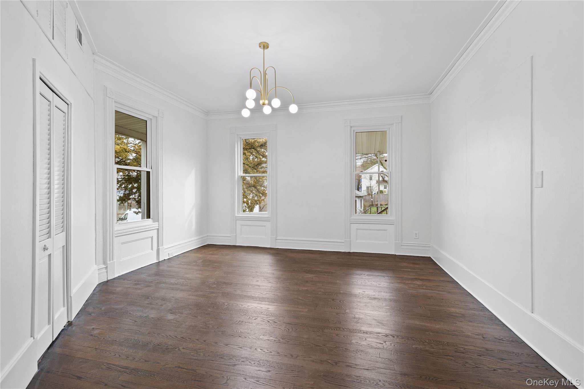 1 Elizabeth Place, Unit 1F Nyack, NY 10960 - Photo 11 of 23 Unfurnished dining area featuring crown molding, a decorative wall, a chandelier, and dark wood finished floors