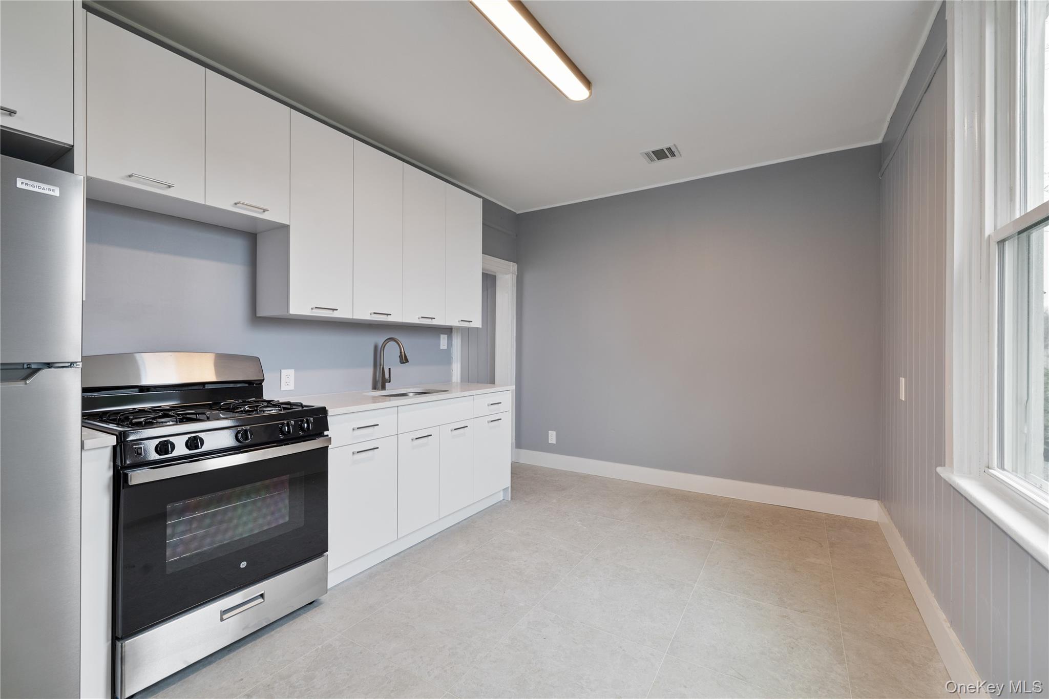 1 Elizabeth Place, Unit 1F Nyack, NY 10960 - Photo 21 of 23 Kitchen with white cabinets, visible vents, light countertops, a sink, and stainless steel appliances