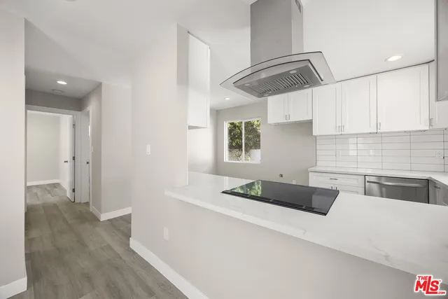 a kitchen with granite countertop a stove a sink and a refrigerator