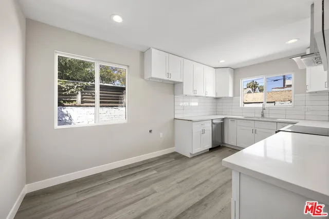 a kitchen with a sink cabinets a counter top space and stainless steel appliances