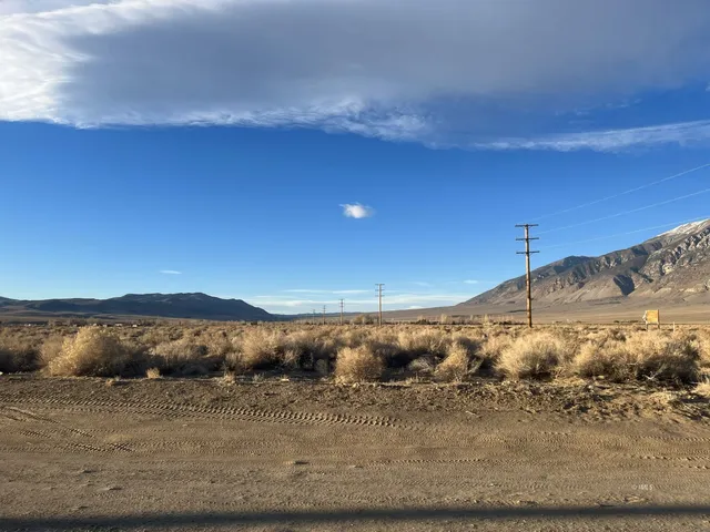 a view of a dry yard with mountains in the background