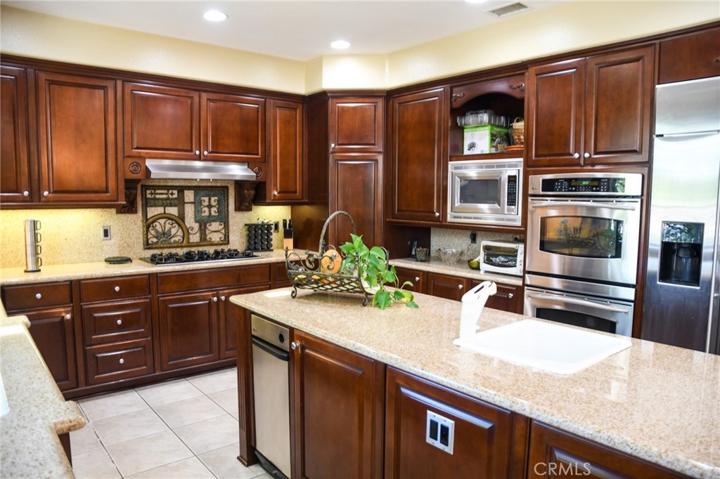 20370 Vía Cellini Porter Ranch, CA 91326 - Photo 5 of 17 a kitchen with stainless steel appliances wooden cabinets and a sink