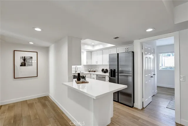 a kitchen with a refrigerator a sink and cabinets