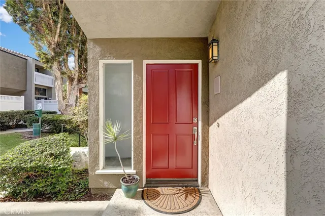 a view of a door with a chair and potted plants